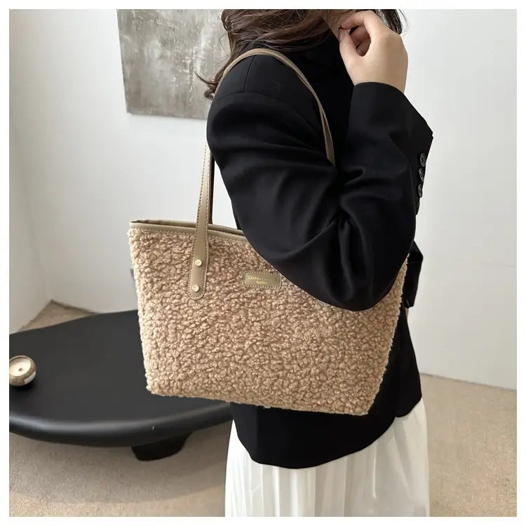 Brown faux fur tote bag featuring beige teddy bear-style texture with tan leather handles and a small metallic plaque.