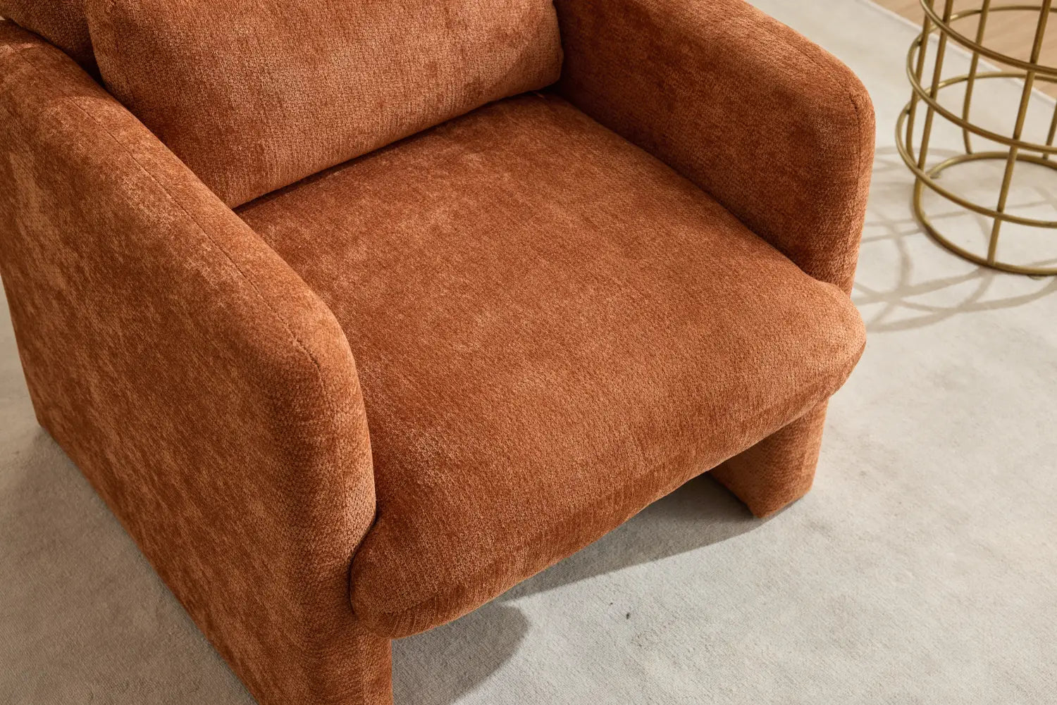 Ein moderner Bouclé-Akzent-Sessel, gepolstert mit rust-orangefarbenem, strukturiertem Stoff, mit abgerundeten, gepolsterten Armlehnen, ausgelegt für gemütliches Sitzen.