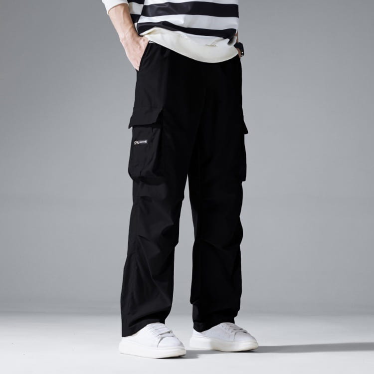 Mens multi pocket cargo workwear pants featuring black fabric with multiple functional pockets and a subtle logo on the thigh.