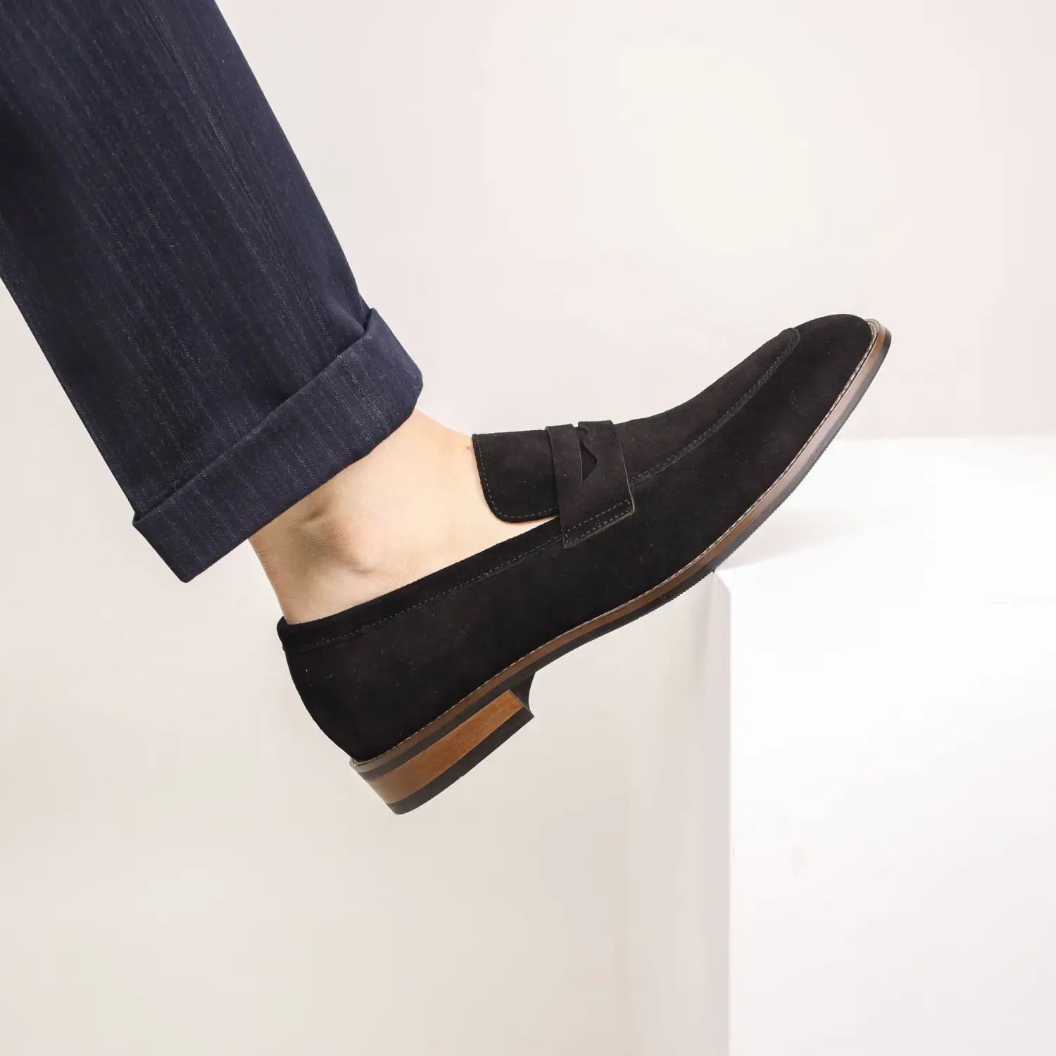 men’s brown suede penny loafer casual leather shoe featuring a black suede upper with a brown leather sole and a classic slip-on design