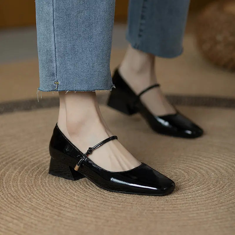black patent leather mary jane heels with a square toe and low block heel suitable for formal and casual wear