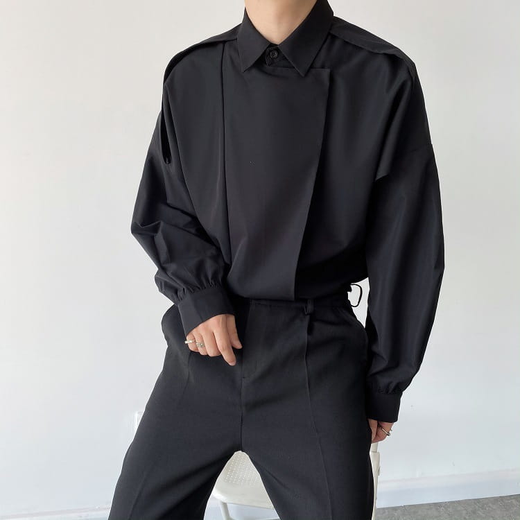 black oversized long sleeve button up shirt for men with structured collar and asymmetrical fabric panels creating an avant-garde silhouette