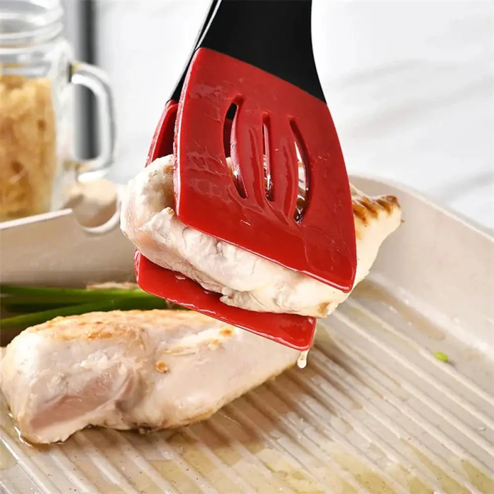 Red silicone slotted spatula with black handle featuring three elongated slots from the 3-in-1 kitchen tongs clip set