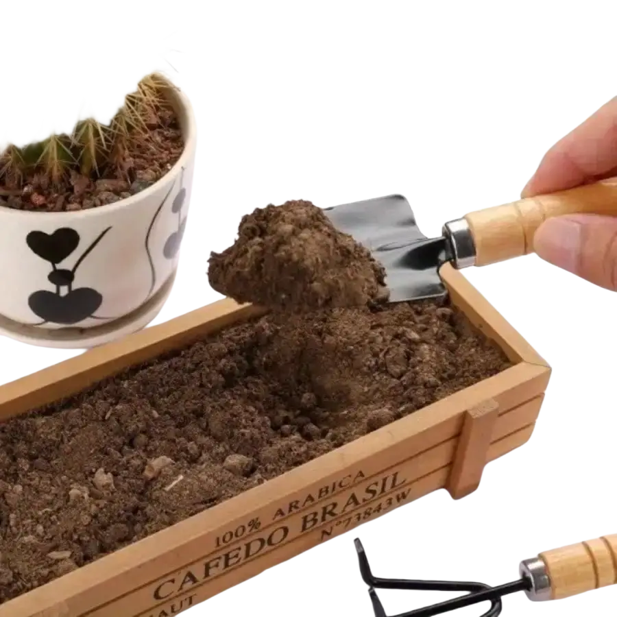 Wooden-handled garden trowel with metallic blade lifting soil from wooden planter box in 3-piece mini gardening tool set