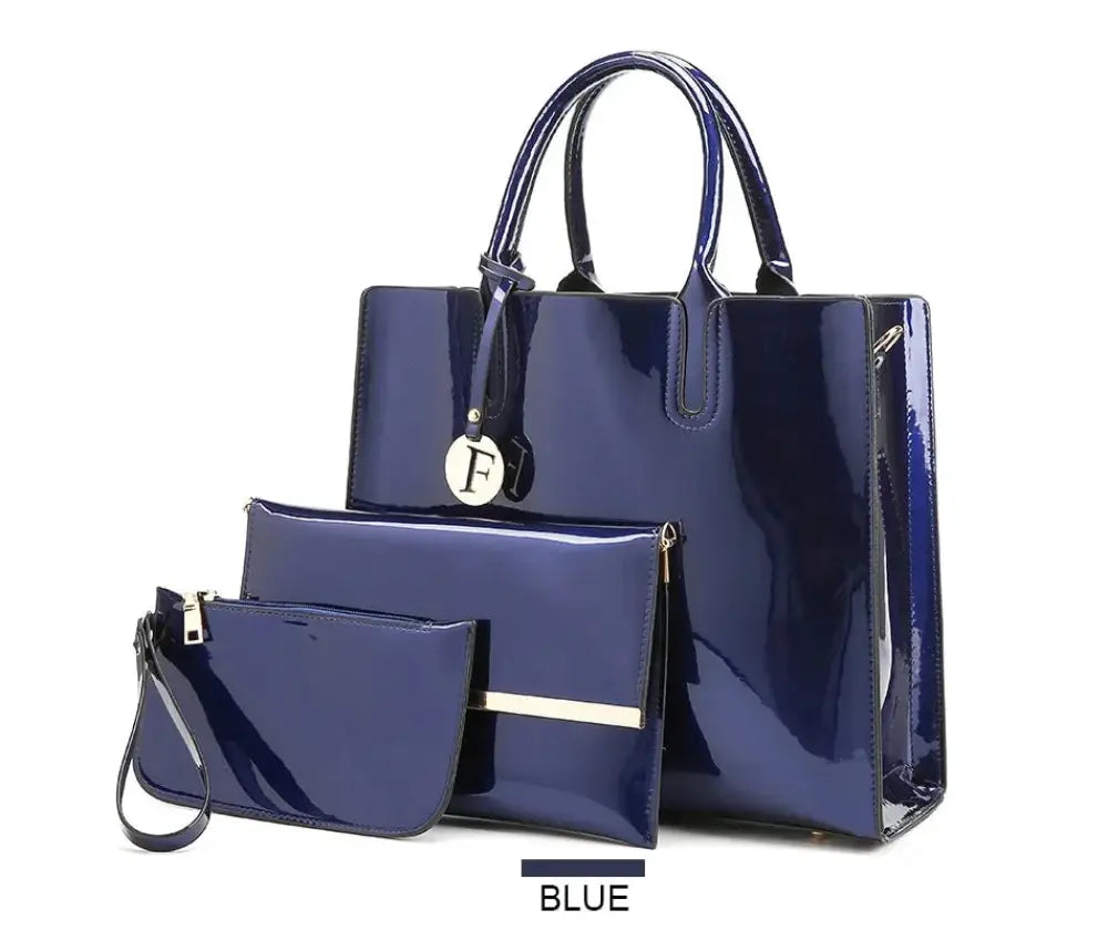 Premium 3-piece crimson leather tote and clutch set featuring a navy blue patent leather handbag with metallic accents and a monogrammed charm