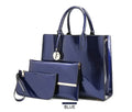Premium 3-piece crimson leather tote and clutch set featuring a navy blue patent leather handbag with metallic accents and a monogrammed charm