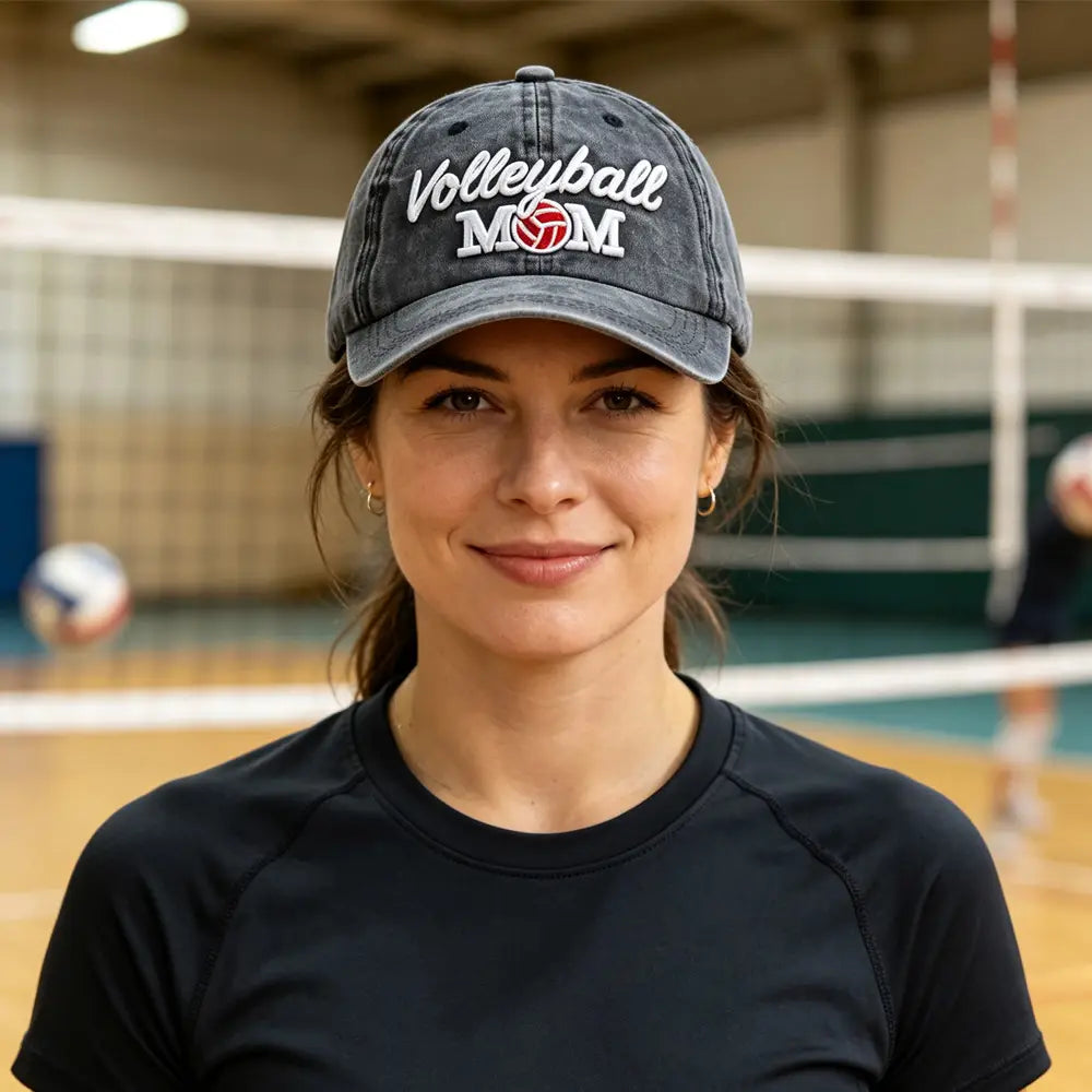 Une casquette de baseball vintage en denim délavé, brodée « volleyball mom » en blanc et rouge.