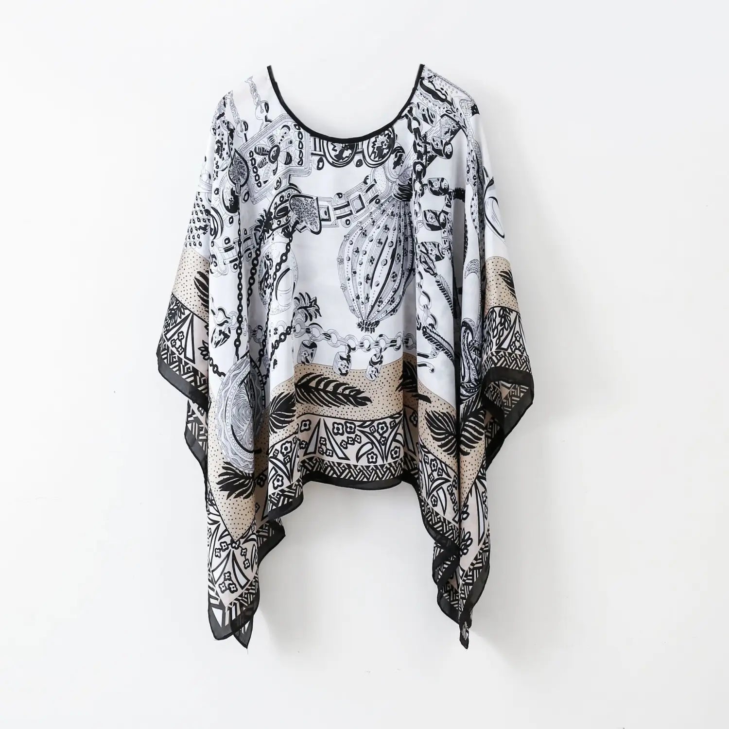 A flowing white black and beige chiffon printed silk patterned pullover shawl cape outerwear with intricate chain and feather motifs.