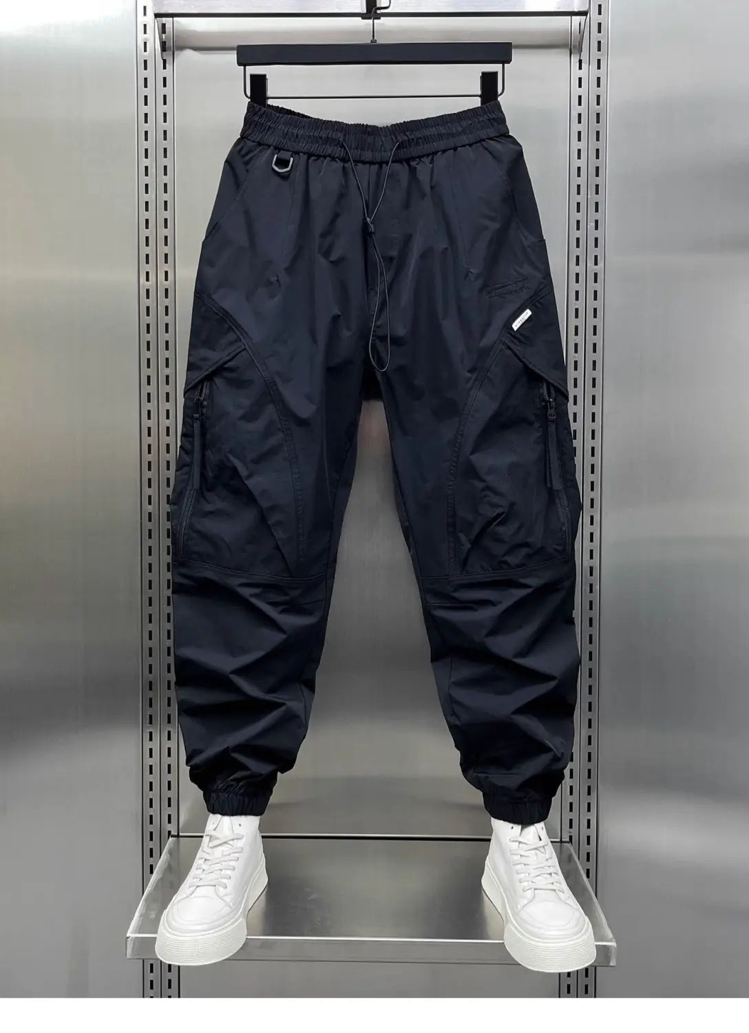 men’s tapered cargo joggers in black with elastic waistband drawstring multiple pockets and tapered leg design.