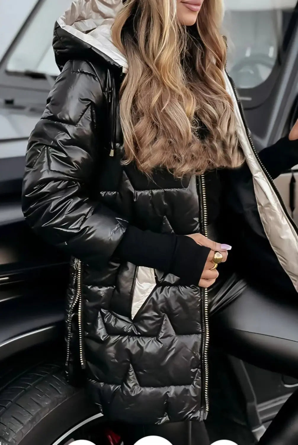 Black glossy hooded down puffer jacket with a shiny quilted exterior and a contrasting silver-lined hood.