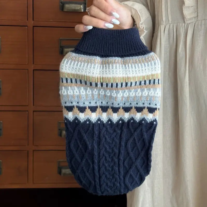 Ein marineblauer und cremefarbener Hundepullover aus weichem Strick mit hohem Kragen und filigranen beigen und weißen geometrischen Fair-Isle-Mustern, entworfen als Heimtierbedarf.