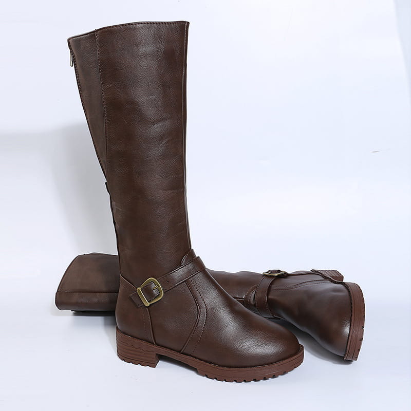 Leather knee high knight boots in brown leather featuring a gold toned buckle strap and a textured rubber sole.