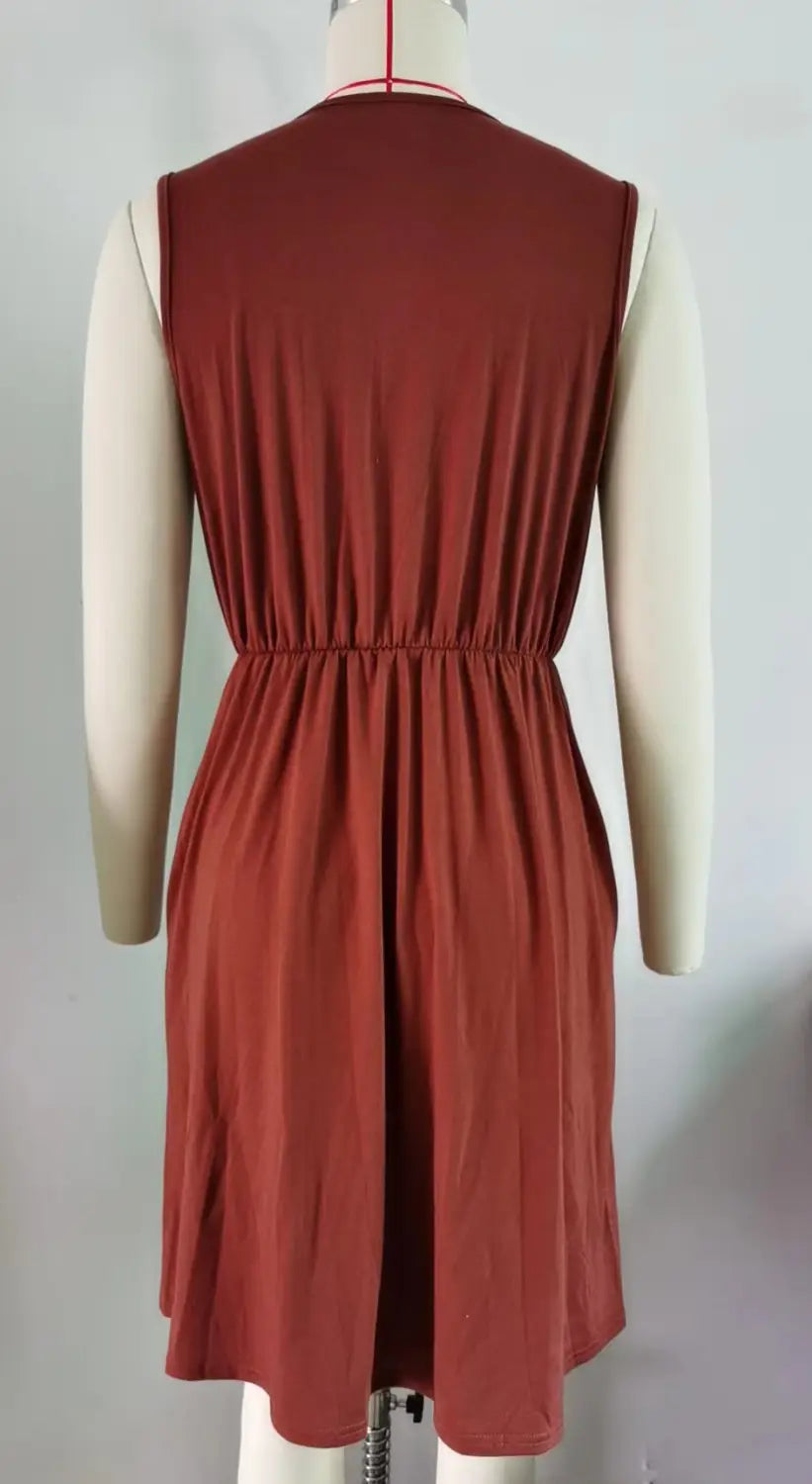 Ein ärmelloses rostfarbenes A-Linien-Kleid mit V-Ausschnitt und Spitzenbesatz, mit geraffter Taille aus weichem Stoff und mit Taschen.