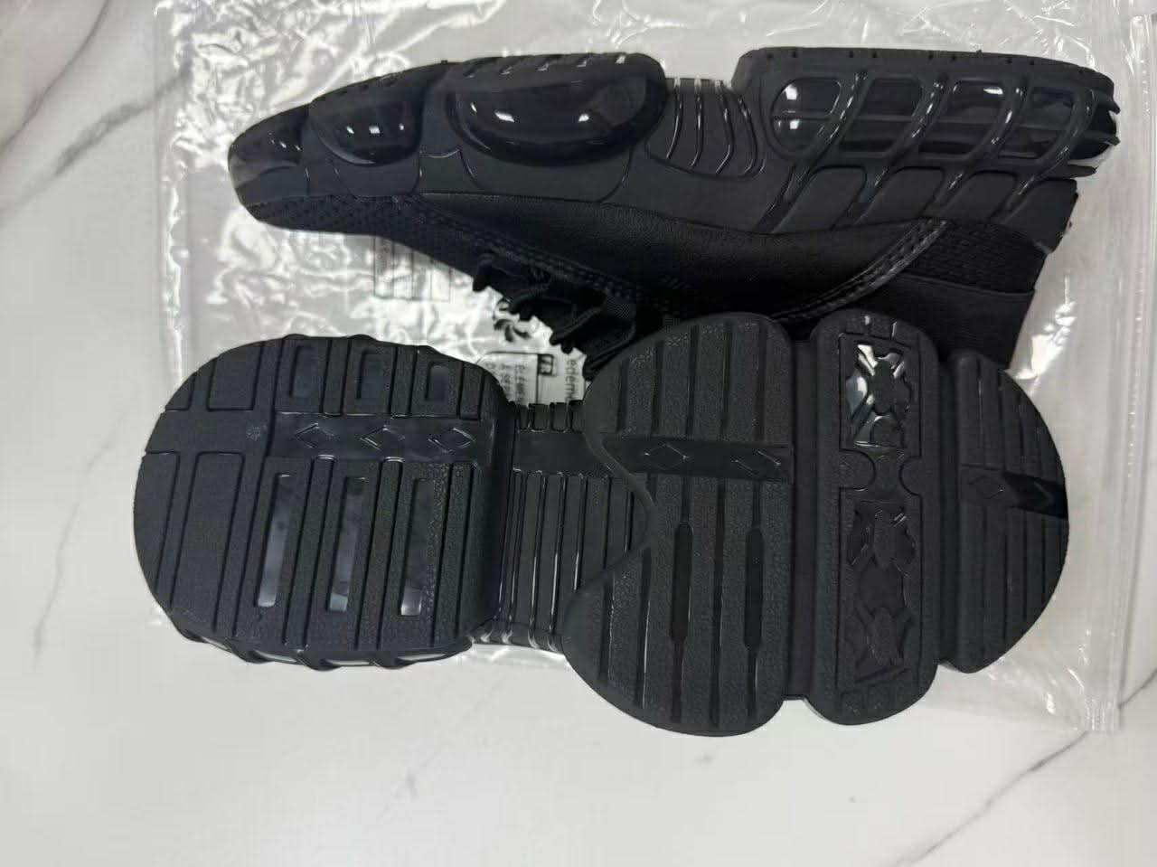Schwarze klobige Mesh-Laufsneaker mit einem leichten, atmungsaktiven Design; mit einer strukturierten Sohle und glänzenden Gummizierakzenten.