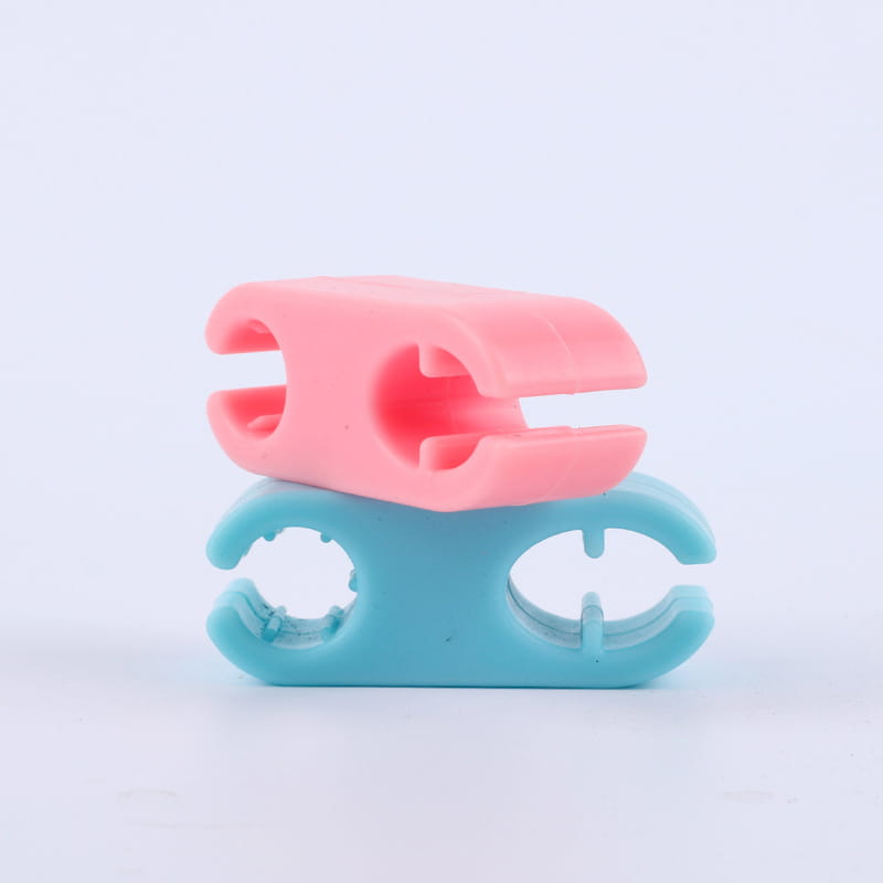 pink and teal plastic clip holders stacked together as part of a pet selfie phone clip and dog toy set designed for securing phones and entertaining dogs.
