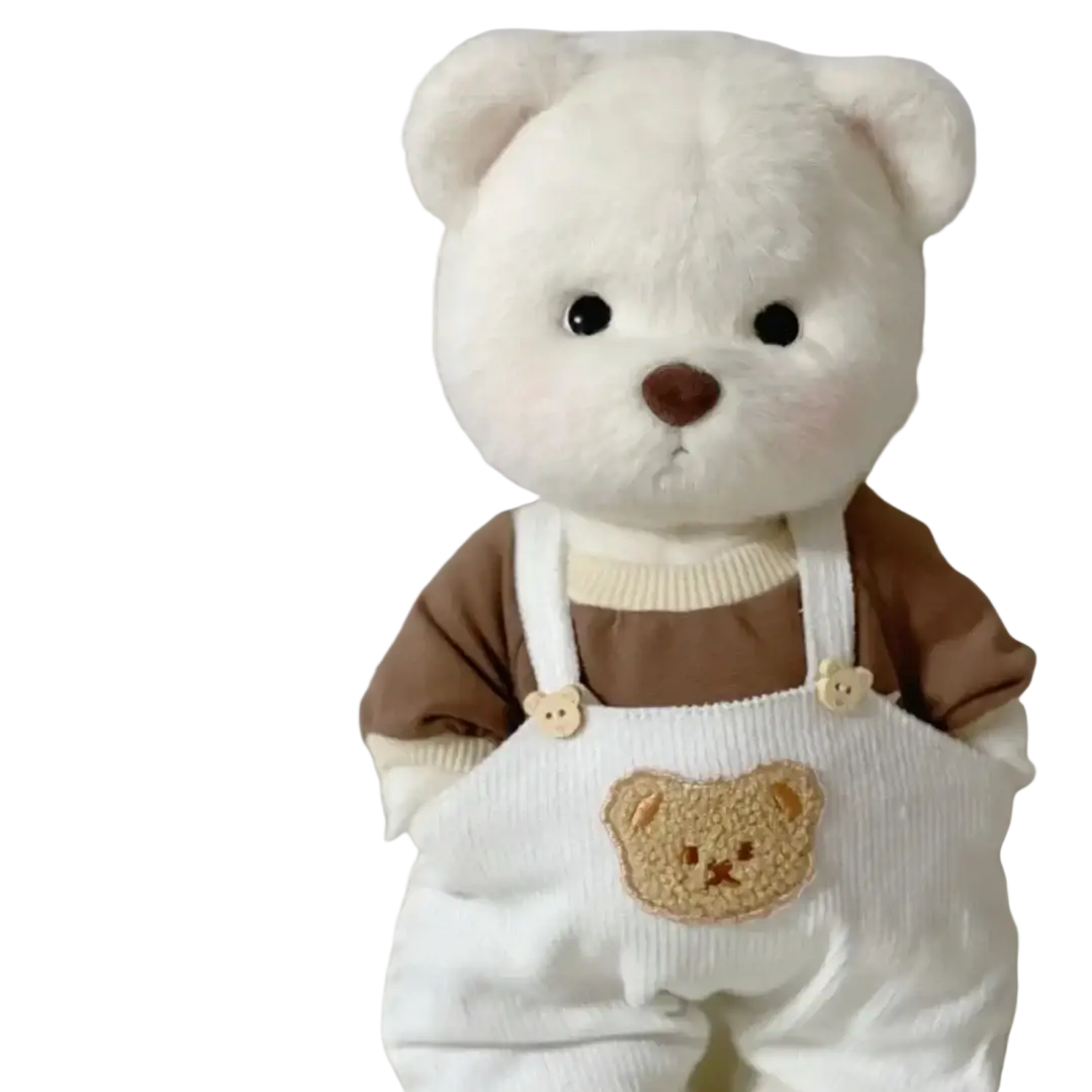 A 30cm nude bear plush with white corduroy overalls and brown knit sleeves featuring a tan embroidered bear face patch