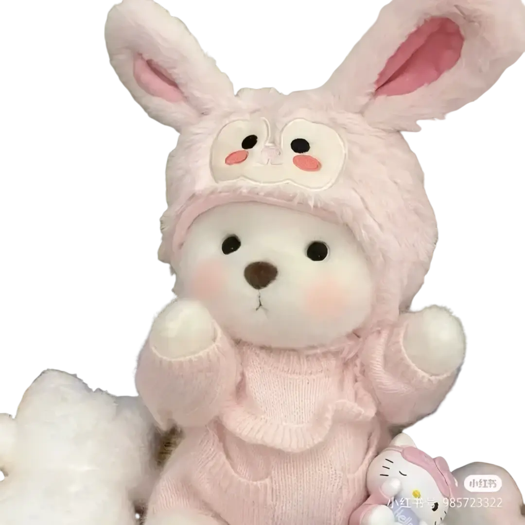A soft pink plush nude bear 30cm wearing a knitted sweater and fuzzy hat with embroidered cheeks and ears