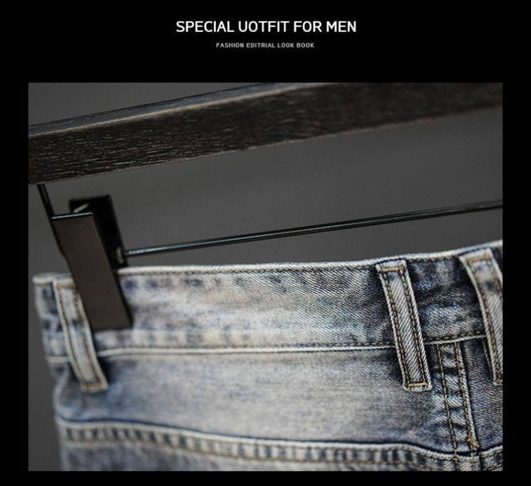 A pair of distressed maple leaf denim shorts in faded blue wash with visible stitching hanging on a black metal hanger.