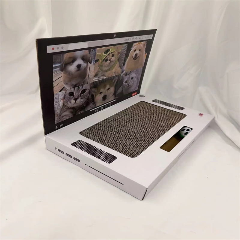 Weißer Pappkarton-Laptop-Kratzpappen-Spielzeug-Notizblock mit einem Bildschirm, der niedliche Hunde und Katzen zeigt, einem Kratzpad im Bereich der Tastatur sowie einer kleinen Panda-Figur, die aus einem Schlitz hervorschaut.