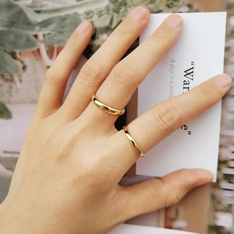 Polished gold tungsten steel couple wedding bands featuring a gold-toned minimalist design.