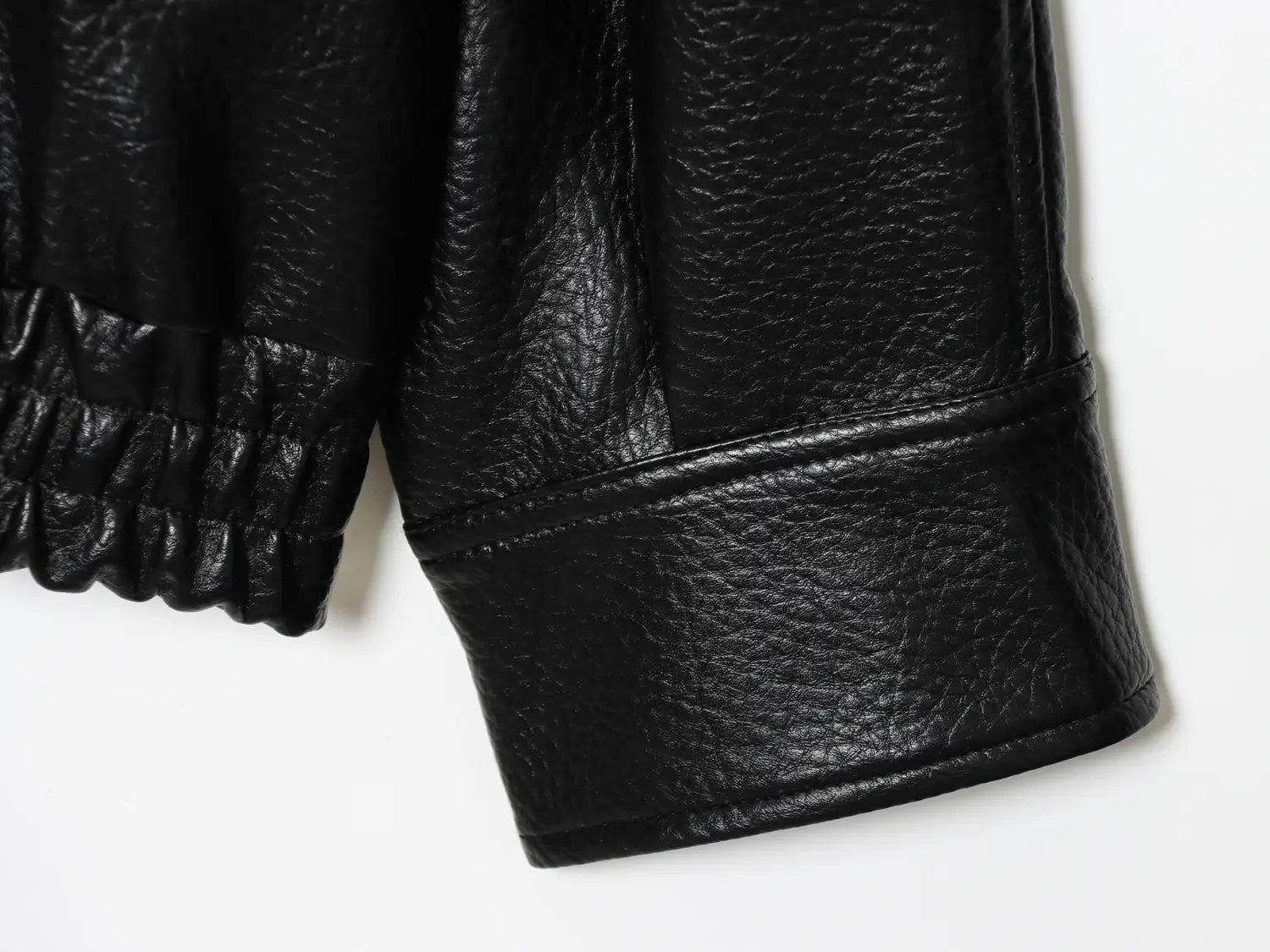 Schwarze Damen-Motorradjacke mit hohem Stehkragen aus Kunstleder, Ärmel mit strukturierter gepunkteter Ausführung und elastischem Bündchen.