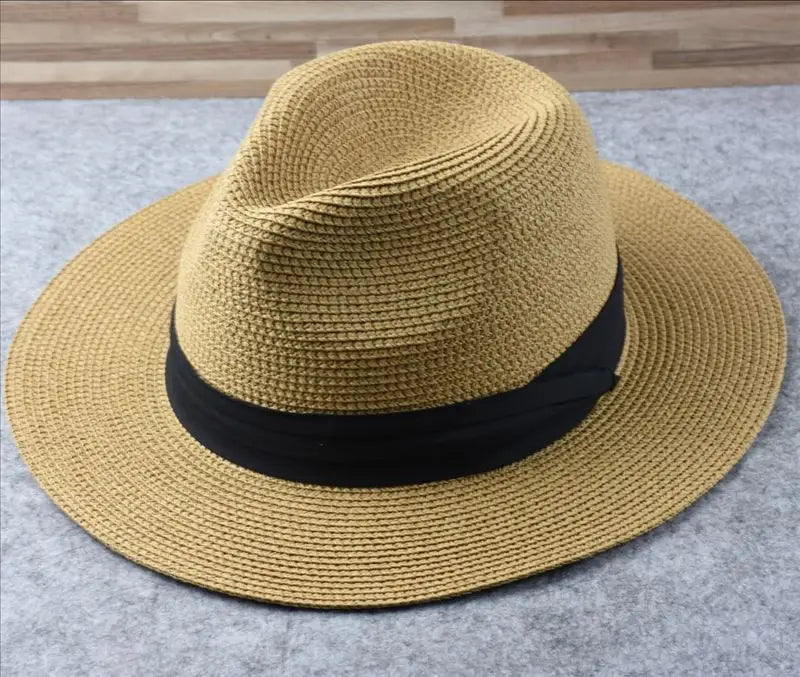 A tan woven straw fedora hat with a black ribbon band designed for foldable sun protection for men.