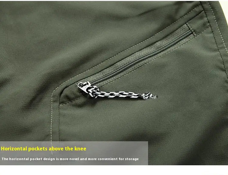 Dark olive green nylon convertible tactical hiking pants with a horizontal zippered pocket and black and white striped pull tab.