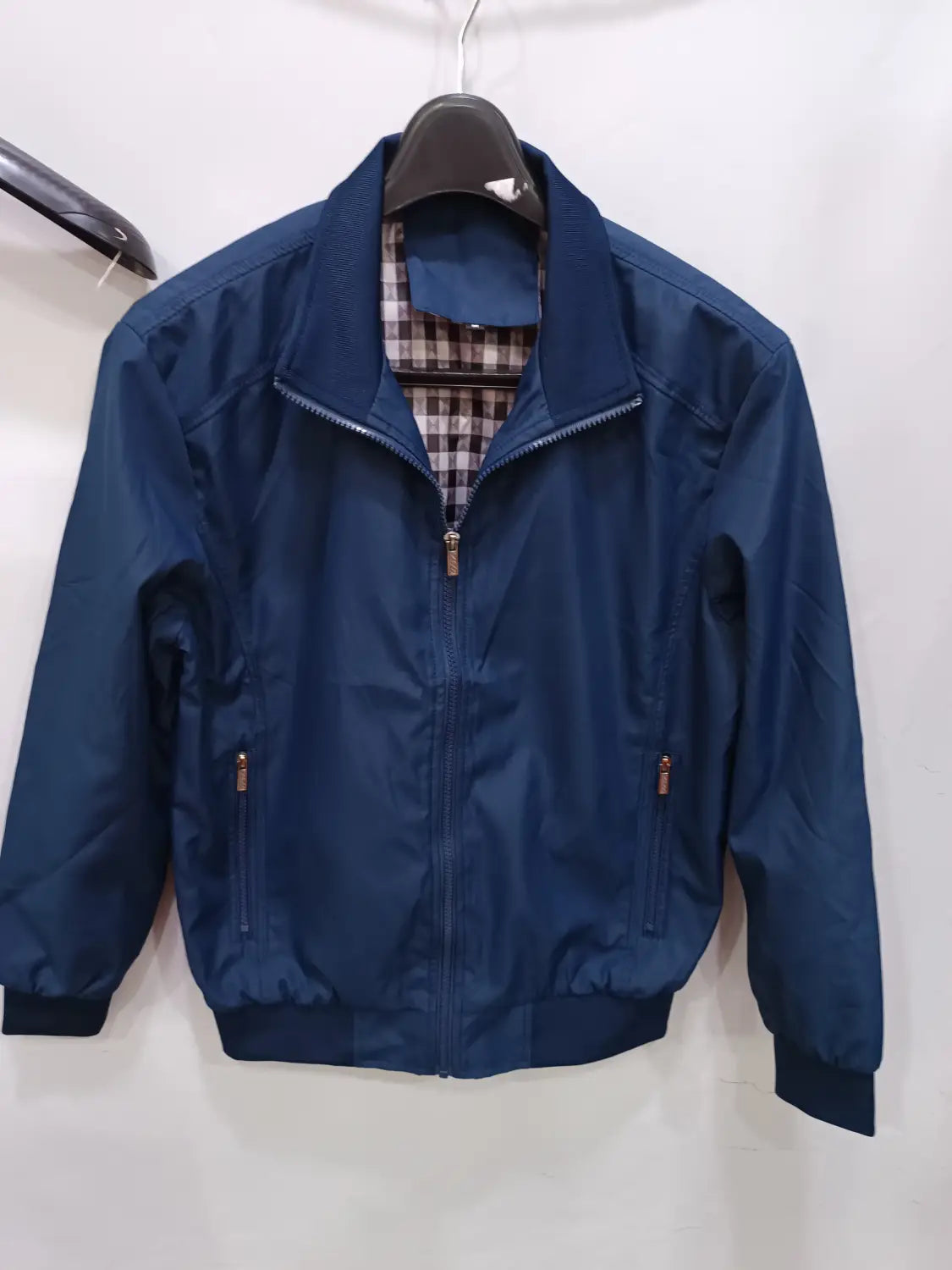 Veste bombardier légère pour homme en nylon bleu marine, avec doublure intérieure à carreaux et accents de fermeture éclair ton or.
