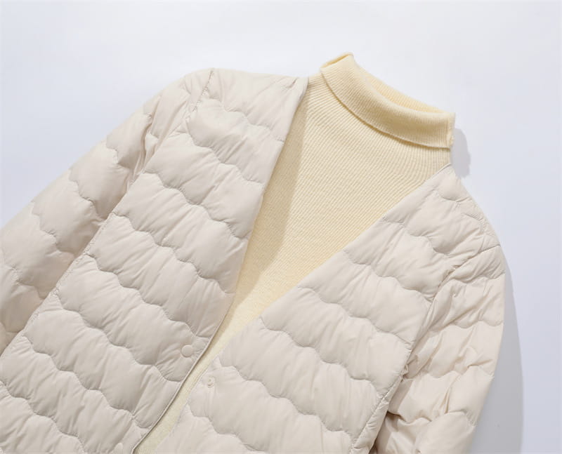 Cream-colored quilted puffer jacket with a soft padded texture and high collar from the Puff Jacket Ruffled Crew Neck collection.