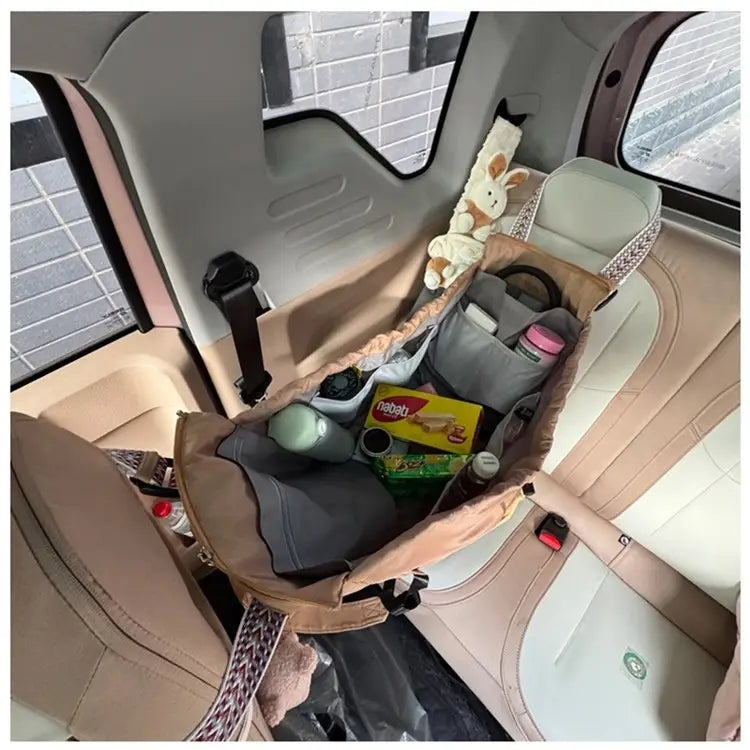 Beige and gray multifunctional waterproof nylon fabric car seat organizer with multiple compartments holding snacks bottles and a plush toy in a fashion tote and backpack design.
