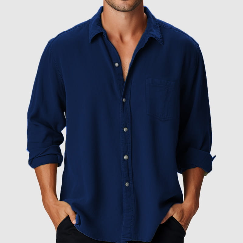 Herren-Longsleeve-Freizeithemd am Strand in tiefem Marineblau mit Knopfleiste vorne, hochgekrempelten Ärmeln und klassischem Kragen.