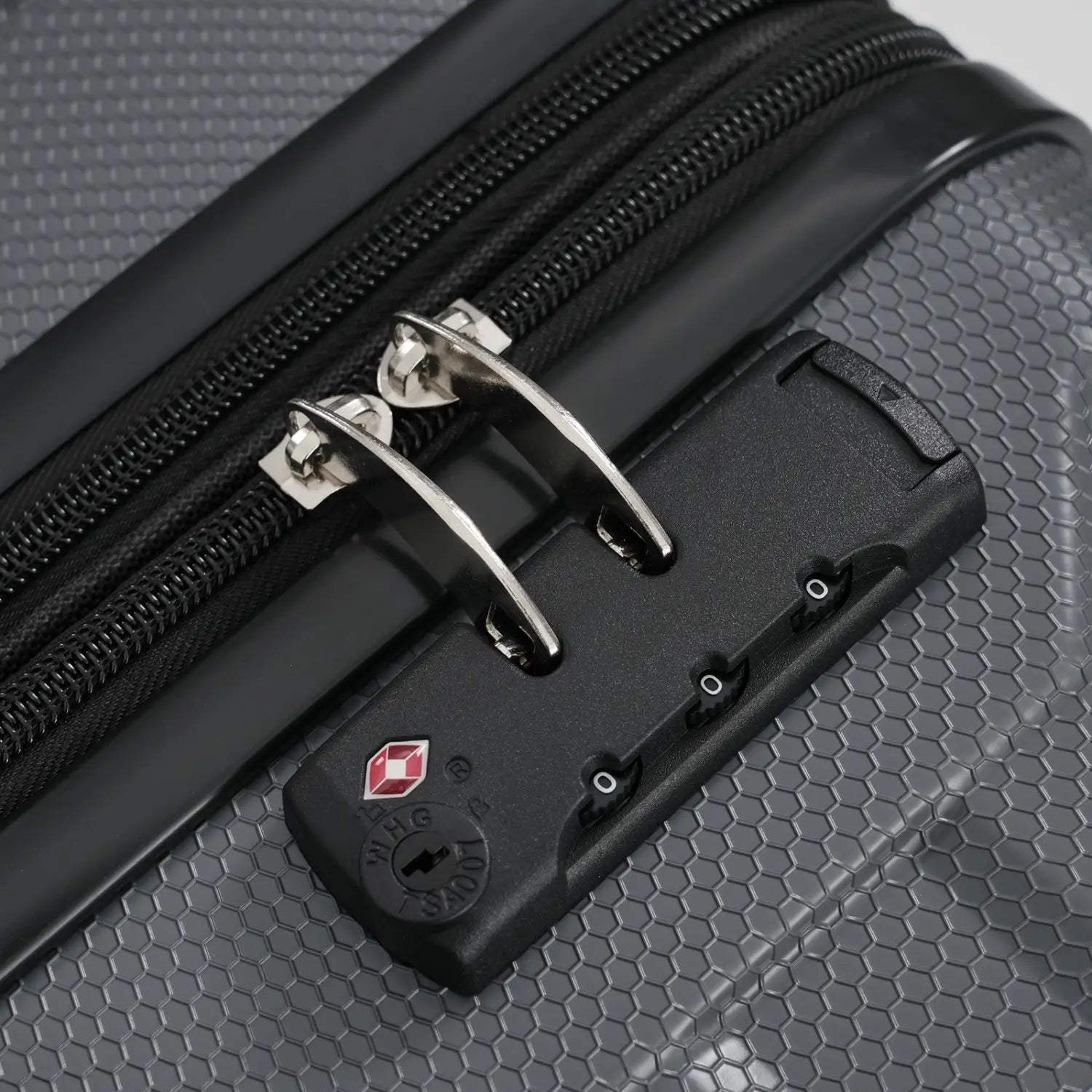 Black 24 inch expandable hardshell checked luggage with hexagonal textured surface silver zipper pulls and swiss travel system tsa combination lock.