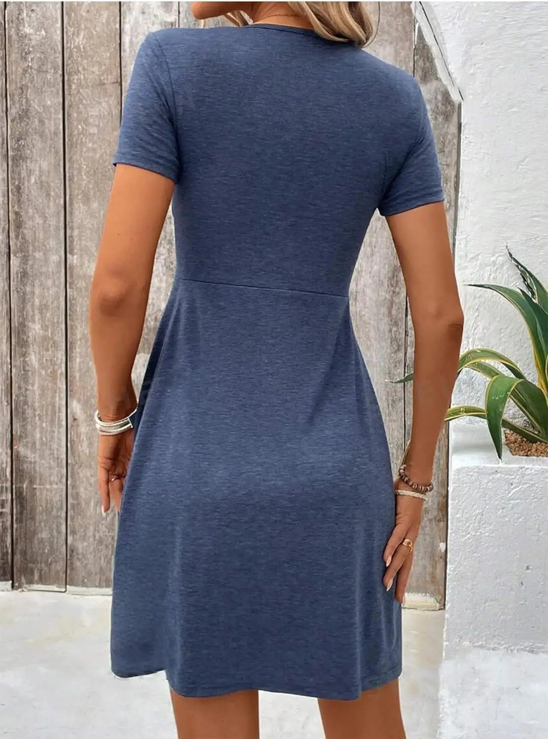 A navy blue twist front v neck short sleeve midi dress with a fitted bodice and flared skirt.