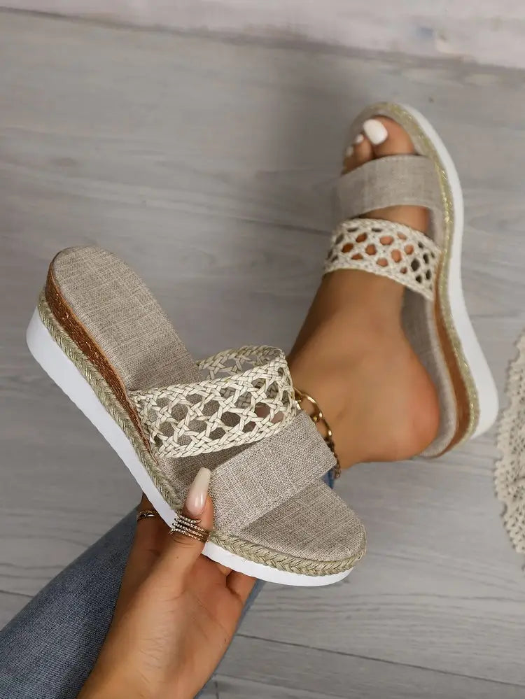 Beige woven espadrille slide sandals with a textured fabric upper and decorative lace detailing in a women’s mesh espadrille platform wedge design.