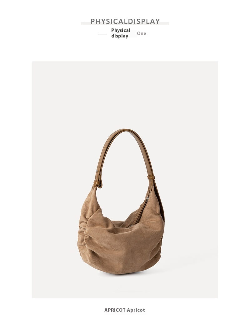 A soft slouchy tan suede shoulder bag with gently curved handles designed as a crossbody hobo.