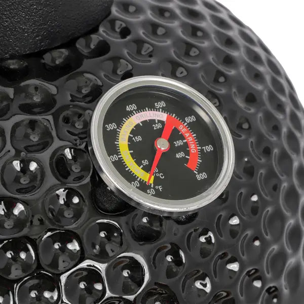 black textured ceramic 13 inch kamado charcoal grill with circular temperature gauge displaying red and yellow cooking zones