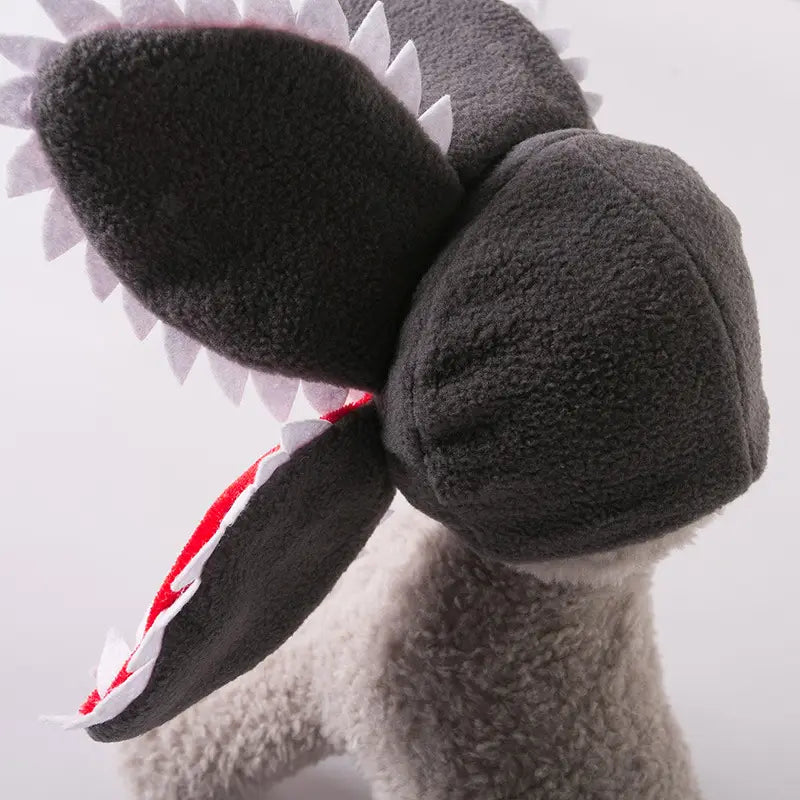 A plush gray shark toy with white triangular teeth and a red-striped interior mouth featured as a carnivorous flower dog hat plush pet costume.