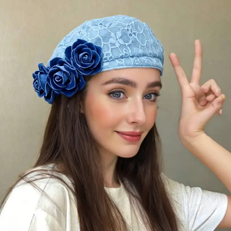 Hellblaues Spitzen-Denim-Baskenmützchen, verziert mit drei tiefblauen Stoffrosen, die dreidimensionale Kontrastblumen zur Schau stellen.