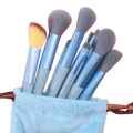 Set of ten blue-handled makeup brushes with nylon bristle material in a light blue plush pouch from 33-piece set