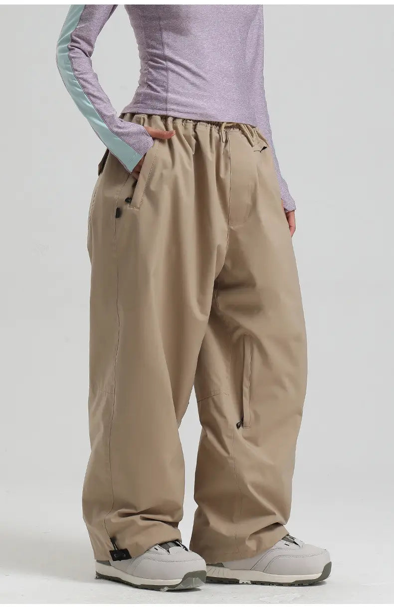 Beige waterproof windproof snow pants with a drawstring waist, side pockets, and subtle stitching details designed as loose work trousers.