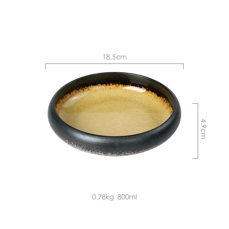 A sleek black ceramic bowl with a glossy golden brown interior glaze and subtle speckled texture made from kiln glazed bone china.