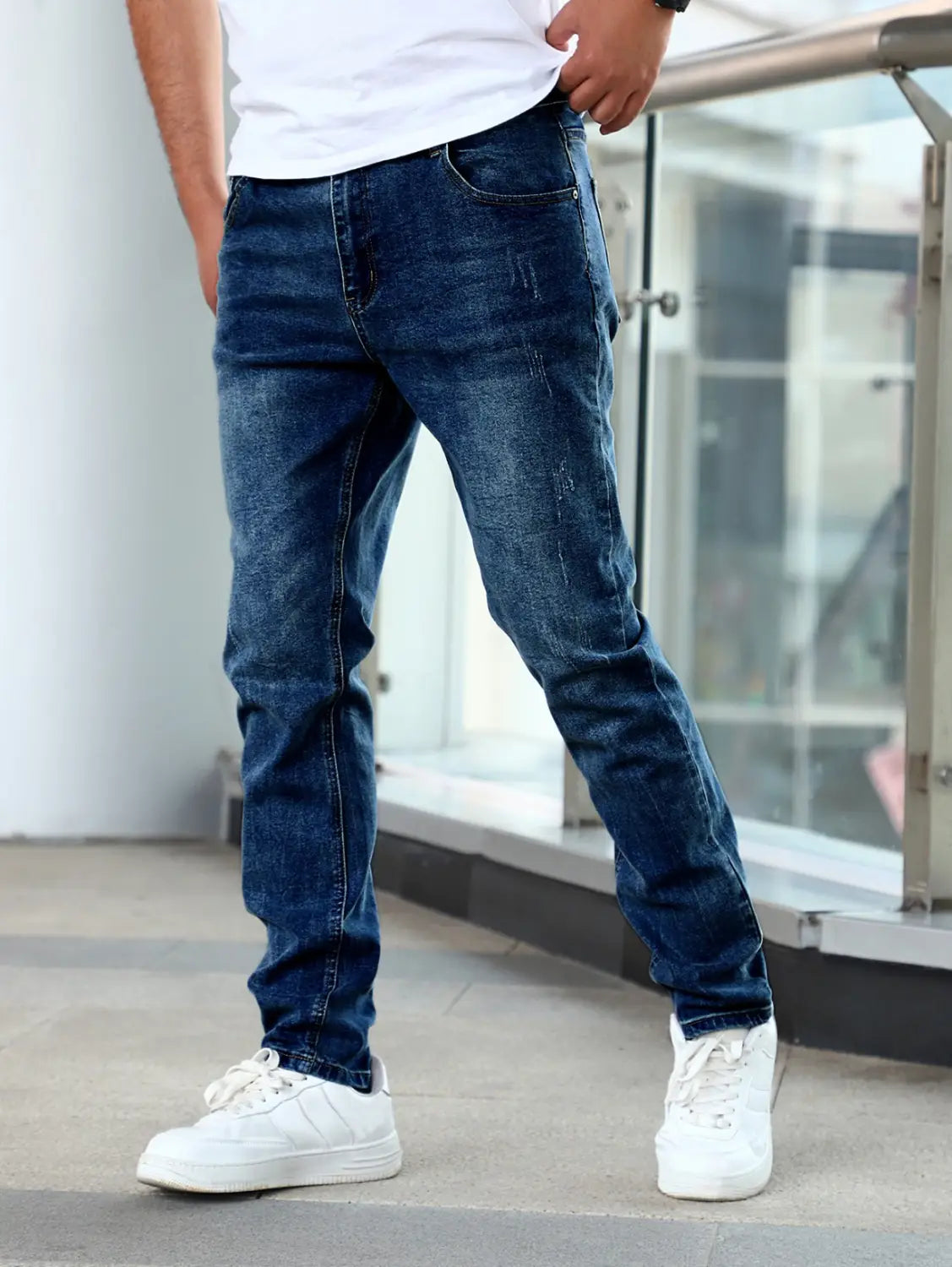 Men’s slim fit distressed dark wash denim jeans made of dark blue denim with subtle distressed details.
