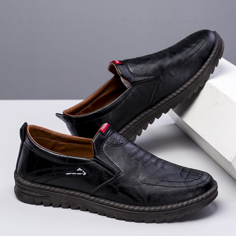 Men’s lightweight breathable white faux leather slip on shoe with brown embroidered detailing and textured rubber sole
