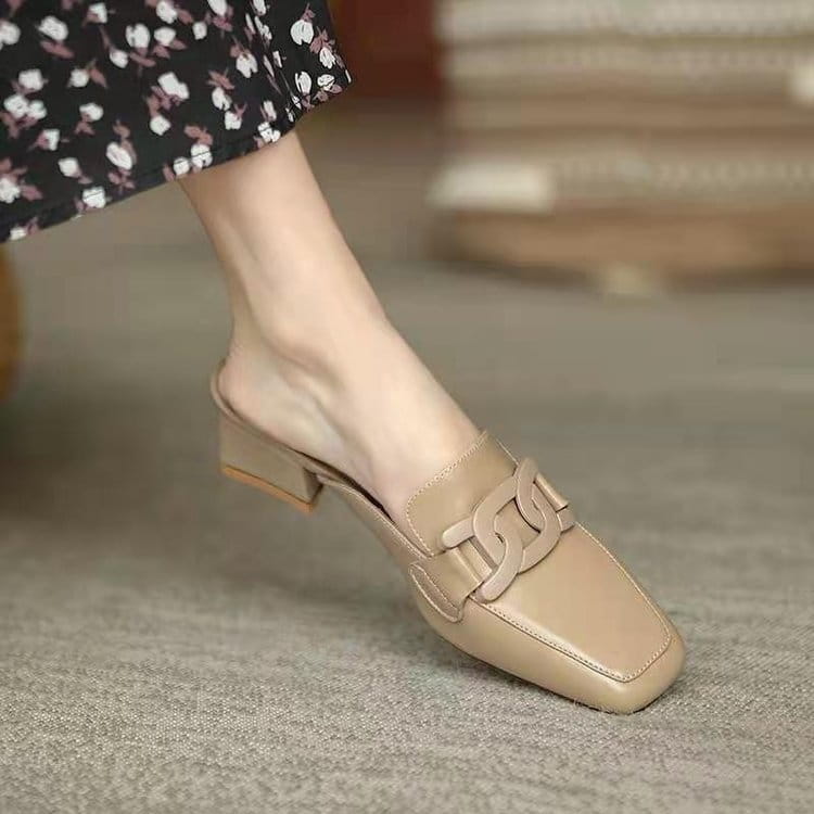 Beige leather loafers with metal buckle, square toe, and chain-link strap detail.