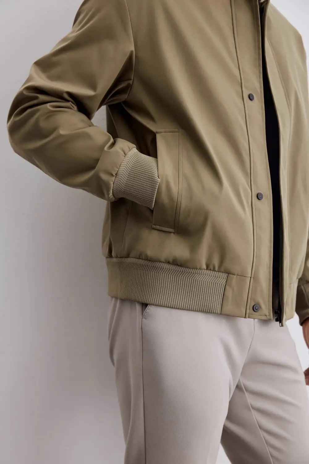 Herren-Jacke mit gestepptem Revers, für die Geschäftsführung, in Olivgrün, mit gerippten Bündchen und Saum sowie einem Knopfverschluss vorne.