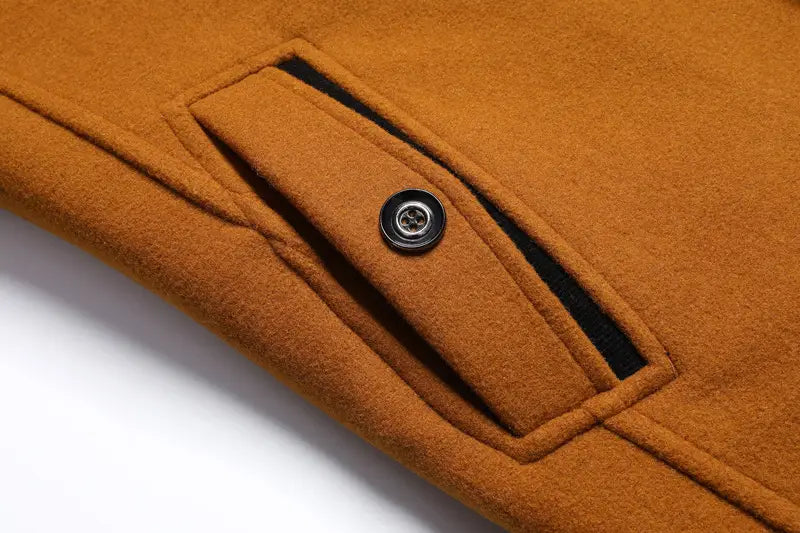 A close-up of a warm brown men wool winter overcoat quilted jacket featuring a black button and contrasting black inner lining.