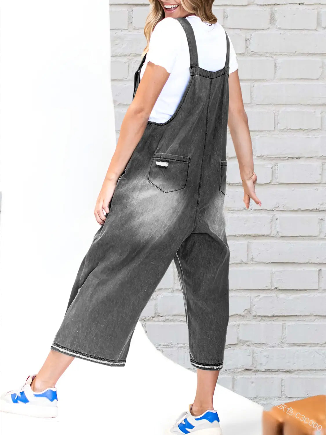 Dark gray distressed denim overalls with a faded wash and wide-leg cut featuring adjustable straps for women.