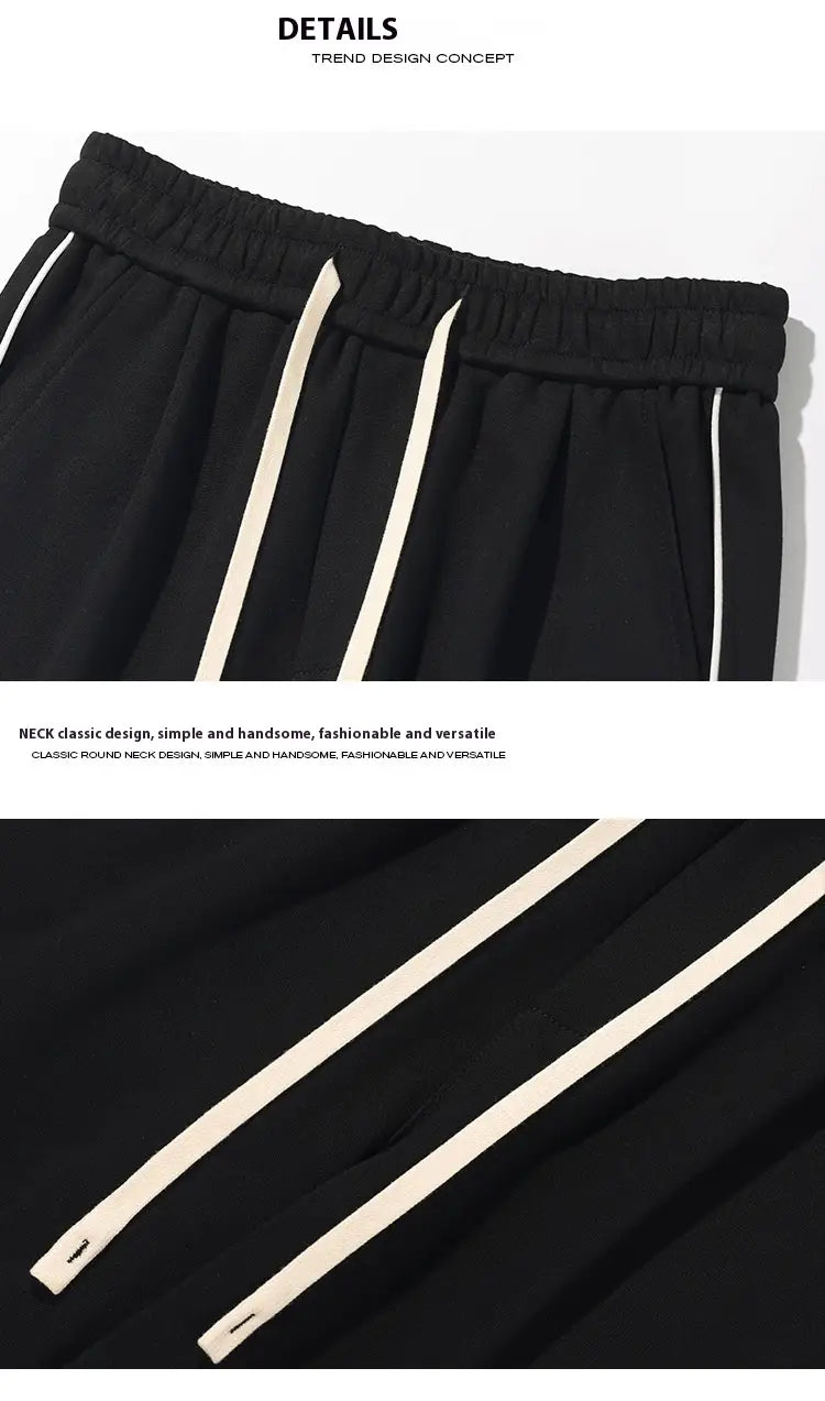 Wide leg striped track pants in black athletic fabric feature contrasting white side stripes and an elastic waistband for comfort.