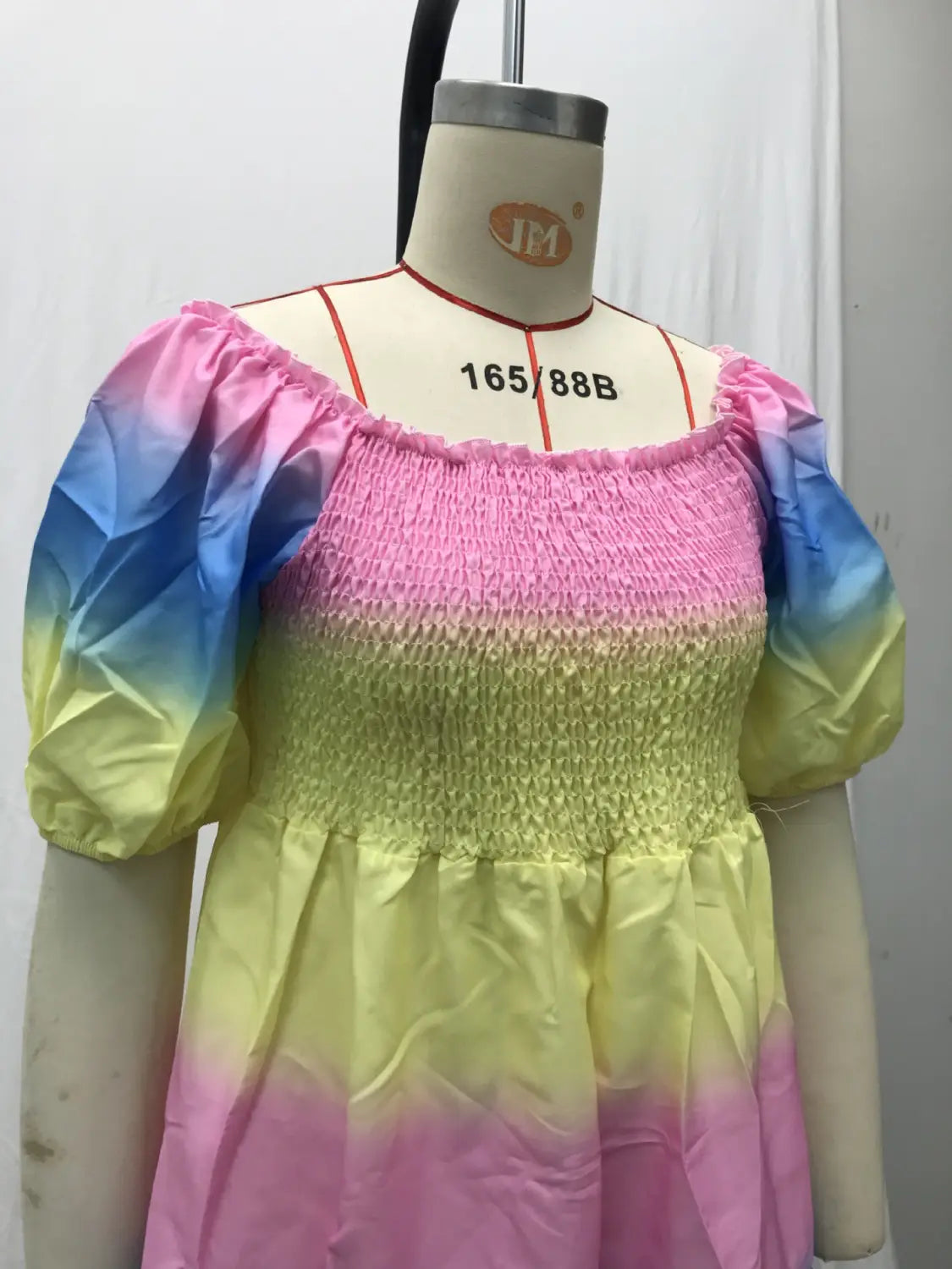 Pastel rainbow gradient smocked dress with puffy short sleeves and off-the-shoulder neckline featuring a floral print and tiered midi design with square neckline.