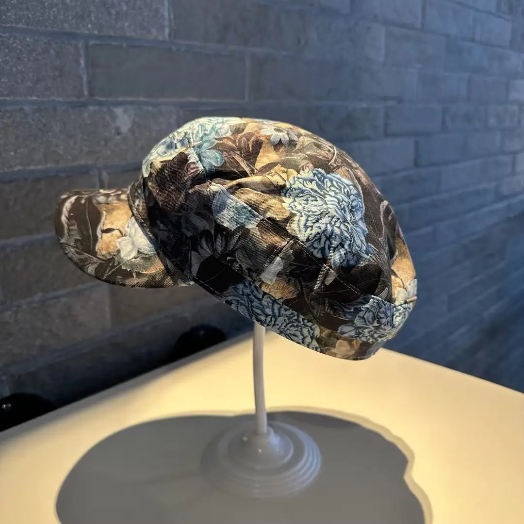 Gorra tipo bucket hat floral elegante, estilo coreano, impresa, en tonos marrón y azul, con acabado de tejido de textura suave.